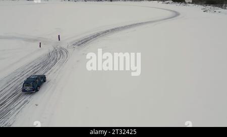 Winterspaß aus einem Hubschrauber gefilmt. Clip. Winterliche Treiben in Autos, die zu Wettbewerben gehen und Leute beobachten. Stockfoto