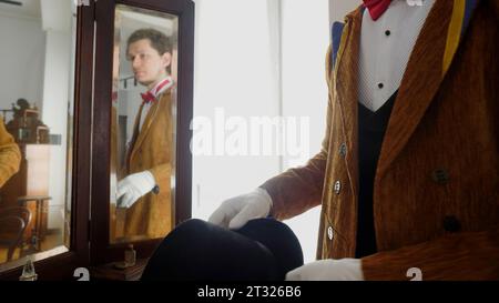 Der Mann ist ein Zauberer. Archivmaterial. Ein junger Schauspieler in braunem Anzug mit Hut, der der Aufführung zugeteilt wird. Stockfoto