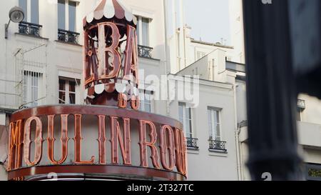 Paris, Frankreich - 19. august 2022: Moulin Rouge-Schild auf der Straße. Aktion. Stadtstraße und Wohngebäude im Hintergrund. Stockfoto