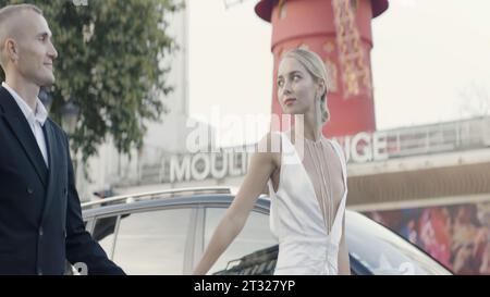 Paris, Frankreich - 19. august 2022: Moulin Rouge-Schild auf der Straße. Aktion. Braut und Bräutigam an ihrem Hochzeitstag in Paris. Stockfoto