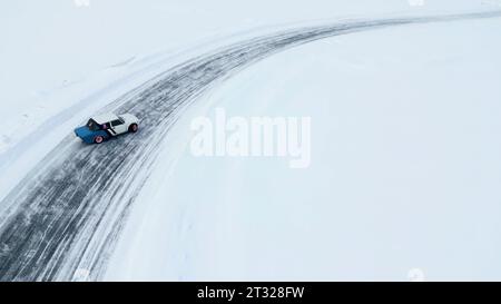 Aus der Vogelperspektive eines Rennwagens, der sich schnell durch die Schneewüste bewegt. Clip. Konzept von aktivem Lebensstil und Sport. Stockfoto