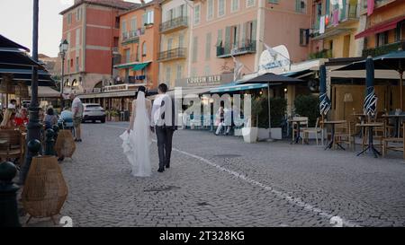 Venedig – italien, 25. September 2022: Braut und Bräutigam spazieren in einer Stadtstraße am Sommertag. Aktion. Sommerstraße mit Restaurants und Leuten. Stockfoto