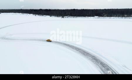 Aus der Vogelperspektive eines Rennwagens, der sich schnell durch die Schneewüste bewegt. Clip. Konzept von aktivem Lebensstil und Sport. Stockfoto