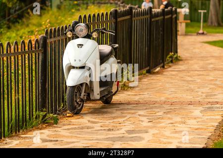 Ein kleines Motorrad parkt am Zaun in der Türkei Stockfoto