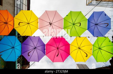 Hängende farbige Regenschirme, die von unten gesehen werden, schmücken eine Straße in Bogota, Kolumbien Stockfoto