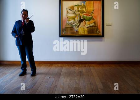 Bogota, Kolumbien - 2. Januar 2023: Wachmann spricht im Radio, während er Fernando Boteros Arbeit „Interior“ im Botero Museum ansieht Stockfoto
