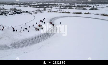 Winterstrecke während des Rennens, Blick von der Drohne. Clip. Aus der Vogelperspektive von Autos, die auf Schnee und eisbedeckten See fahren. Stockfoto