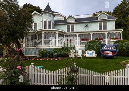 Haus mit Holzveranda auf Mackinac Island und Halloween Dekoration im Vorgarten von Mackinac Housing Development, Mackinac Island, Michigan, USA Stockfoto