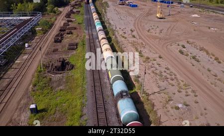 Luftaufnahme eines Güterzuges in der ländlichen Aeria. Clip. Alte Eisenbahnen und die Baustelle. Stockfoto