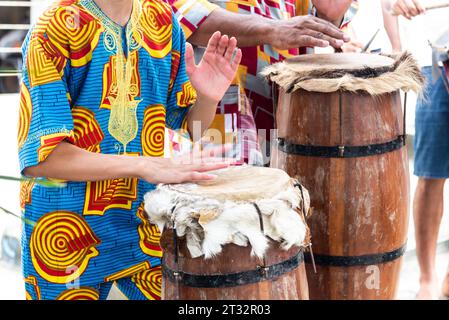 Santo Amaro, Bahia, Brasilien - 12. Juni 2022: Mitglieder von Candomble spielen während einer religiösen Demonstration in der Stadt S ein Schlaginstrument Stockfoto