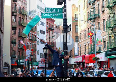 22. Oktober 2023, New York. Die Menschen feiern den Corky Lee Way 李揚國路 Co-Namen der Mosco Street in Manhattan Chinatown. Chris Marte, Mitglied des NYC-Rates, klettert auf einen Lampenpfosten, um das neue Schild zu enthüllen. Corky Lee war ein Fotojournalist, Fotograf und Bürgerrechtler, der die Geschichte Asiens dokumentierte; er wird manchmal als „inoffizieller asiatisch-amerikanischer Fotograf-Laureat“ bezeichnet. Herr Lee starb 2021 an Komplikationen aufgrund von COVID-19. Stockfoto