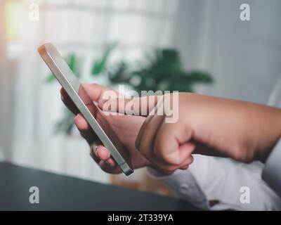 Die menschliche Hand hält ein Smartphone, das das Konzept der Kommunikationstechnologie zeigt. Stockfoto