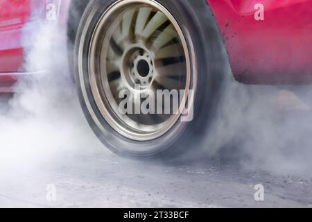 Ziehen Sie den brennenden Reifen des Rennwagens an der Startlinie auf der Rennstrecke Stockfoto