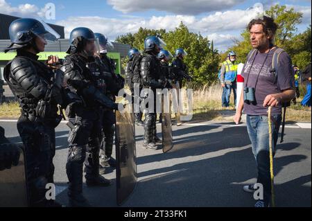 Julien Le Guet, Anführer des Kampfes gegen die Mega-Becken in Sainte-Soline, überprüft und bemerkt die fehlenden RIO-Identifikationsnummern der Polizei und des CRS. Eine CRS-Frau, Kamera in der Hand, filmt die Szene. Prozession öffnen. Demonstration gegen das Autobahnprojekt A69 zwischen Toulouse und Castres. Die Mobilisierung namens Ramdam sur le macadam hat laut den Organisatoren mehr als 9.500 Menschen zusammengeführt. Frankreich, Saix am 21. Oktober 2023. Foto: Patricia Huchot-Boissier/ABACAPRESS.COM Credit: Abaca Press/Alamy Live News Stockfoto