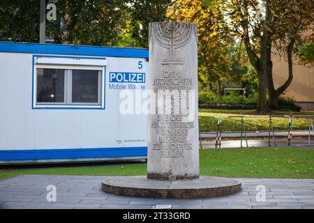 22. Oktober 2023, Sachsen-Anhalt, Dessau-Roßlau: Neben einer Steinsäule steht ein mobiles Polizeirevier an die Alte Synagoge und die Mitglieder der Dessauer jüdischen Gemeinde, die von 1933 bis 1945 Opfer des NS-Terrors wurden. Am selben Tag wurde die neu errichtete Synagoge feierlich nebenan eingeweiht. Foto: Jan Woitas/dpa Stockfoto