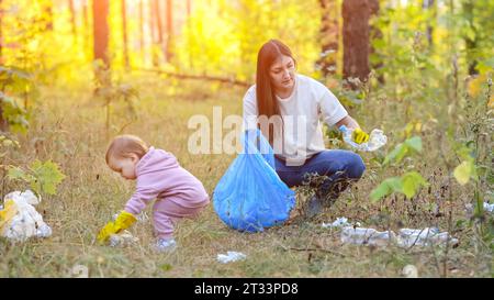 Die Familie hilft der Umwelt, indem sie Müll im Park aufnimmt Stockfoto