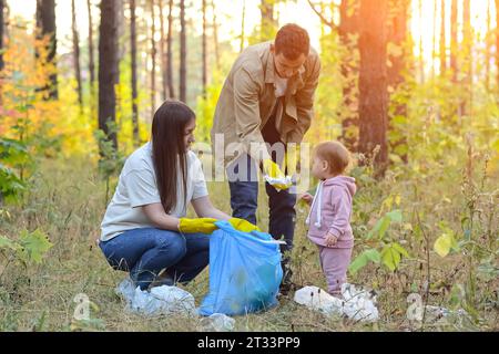 Die Familie hilft der Umwelt, indem sie Müll im Park aufnimmt Stockfoto