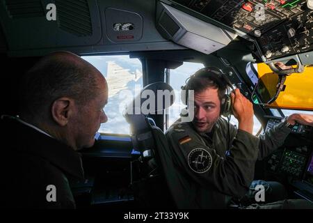 23. Oktober 2023, Brandenburg, Schönefeld: Bundeskanzler Olaf Scholz (SPD) sitzt im Cockpit eines Air Force Airbus A400M für den Flug zum Militärflughafen Köln-Wahn, während ein begleitender Luftwaffe-Eurofighter-Jet startet. Dort nimmt der Kanzler an einer Fähigkeitsdemonstration der Territorialen Disposition Group Teil. Die Fähigkeitsdemonstration beginnt mit einem Flug in einem Transportflugzeug (A400M) von Berlin nach Köln. Während des Fluges erhält der Bundeskanzler erste Erklärungen in der A400M über die technische Ausrüstung an Bord sowie einen „Alarmrota“ der Luftwaffe Stockfoto