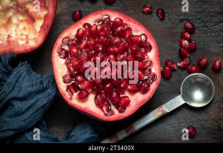 Viele Samen von saftigem, frischem, reifem, rotem Granatapfel auf dem Küchentisch Stockfoto