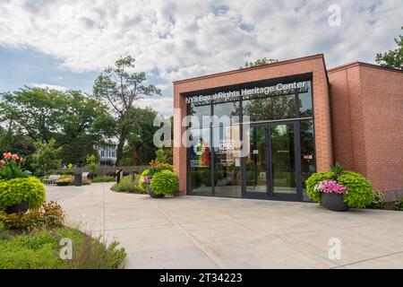 Weitläufiger Blick über einen Betonplatz mit Blumenkübeln in Richtung des Backstein-Eingangspavillons des NYS Equal Rights Heritage Center in Auburn, New York. Stockfoto