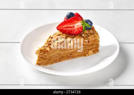 Tortenscheibe mit gekochter Kondensmilch und kandierten Früchten garniert mit Beeren Stockfoto