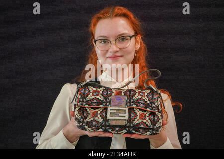 London , Vereinigtes Königreich 23. Oktober 2023. Ein Bonhams Assistent hält eine Fendi: A Beaded and Iridescent Lizard Baguette Bag (Est) £600 - £800 bei der Vorschau des Bonhams Designer Luxury Handtaschen Sale. Der Verkauf findet am 25. Oktober in Bonhams Knightsbridge statt. Credit amer ghazzal/Alamy Live News Stockfoto