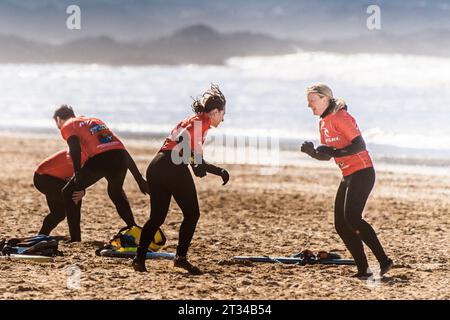 Leute, die sich während einer Surfstunde am Fistral Beach in Newquay in Cornwall in Großbritannien aufwärmen. Stockfoto