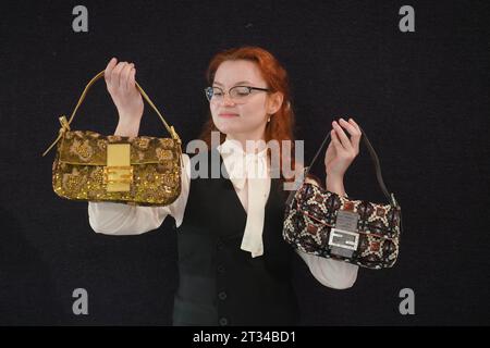 London , Vereinigtes Königreich 23. Oktober 2023. Ein Bonhams-Assistent hält ein Paar Fendi: Eine Baguette-Tasche mit Perlen und Metallic Gold Lizard 2000s (Est) £600 - £800. Bei der Vorschau des Bonhams Designer Luxury Handtaschen Sale. Der Verkauf findet am 25. Oktober in Bonhams Knightsbridge statt. Credit amer ghazzal/Alamy Live News Stockfoto