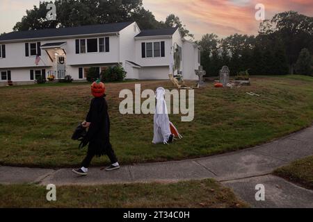 Die Kinder tragen Kostüme für Halloween, die in einer Nachbarschaft spazieren gehen Stockfoto