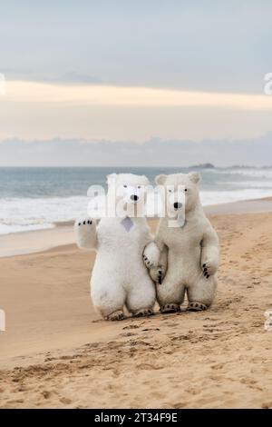 Animateure, die als Eisbären verkleidet sind, unterhalten die Leute am Strand Stockfoto