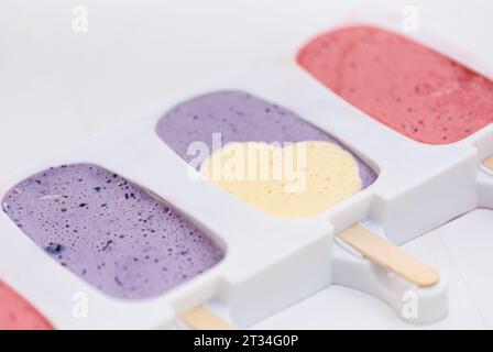 Hausgemachtes, farbenfrohes Fruchteis mit Herzform in Silikoneisform Stockfoto