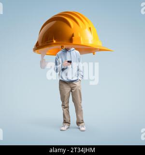 Schutzhelm zum Schutz eines jungen Mannes mit dem Smartphone: Datenschutz- und Sicherheitskonzept Stockfoto