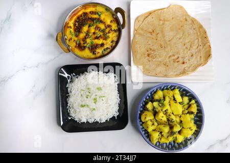 Indische vegetarische Thali oder Platte umfasst Aloo KI Sabji, Dal Reis, Roti Bhaji, Matar Paneer, Sheera oder Suji ka halwa, Chapati. Indisches Essen, sheera. Stockfoto