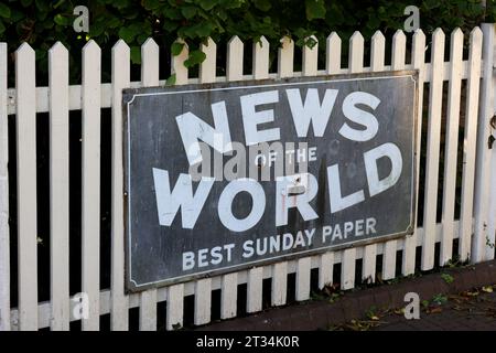 Die Zeitung Old News of the World wirbt auf einem Zaun an der Sheffield Park Station an der Bluebell Railway in East Sussex, Großbritannien. Stockfoto