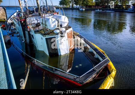 Wieck, Deutschland. Oktober 2023. Der ehemalige Fischschneider Nordland III, erbaut 1944, liegt nach der Sturmflut an der Ostseeküste teilweise vor dem Stauwerk versunken. Die Schäden werden entlang der Ostseeküste dokumentiert und erste Reparaturen und Wiederaufbauarbeiten sind im Gange. Quelle: Jens Büttner/dpa/Alamy Live News Stockfoto