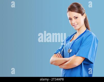 Lächelnde Ärztin posiert mit überkreuzten Armen und Blick auf Kamera, Gesundheitswesen und medizinische Dienstleistungen Konzept, Banner mit Kopierraum Stockfoto