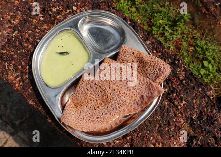 Ragi Ghavne and Chutney, oder Neer Dosa, ist ein beliebtes Frühstücksgericht aus der Konkani- oder südindischen Küche. Ghavne ist ein dünner und zarter Ragi-Krepp Stockfoto