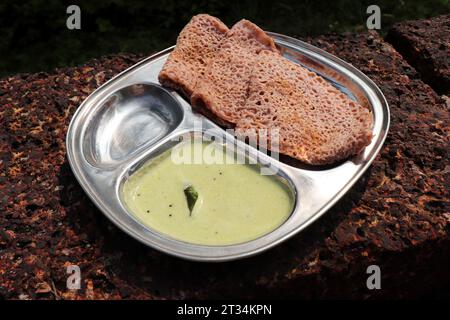 Ragi Ghavne and Chutney, oder Neer Dosa, ist ein beliebtes Frühstücksgericht aus der Konkani- oder südindischen Küche. Ghavne ist ein dünner und zarter Ragi-Krepp Stockfoto