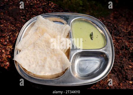 Ghavne and Chutney oder Neer Dosa ist ein beliebtes Frühstücksgericht aus der Konkani- oder südindischen Küche. Ghavne ist ein dünner und delikater Reiskrepesee Stockfoto