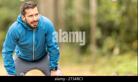 Porträt eines gut aussehenden jungen Athleten in warmer Herbstsportbekleidung. Kopierbereich auf der rechten Seite. Stockfoto