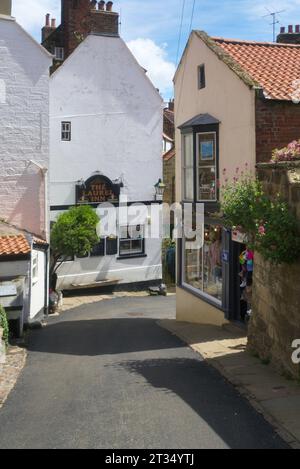 Robin Hood's Bay, mit Blick auf die New Road, zu Geschäften und Laurel Inn. Straße hinunter vom Bank Top Car Park zum Strand und Meer, North Yorkshire; Engla Stockfoto