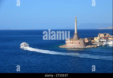 Ein Boot mit dem Goldenen Statut der Madonna della Lettera (Muttergottes des Briefes) steht über dem Eingang zum Hafen von Messina, Sizilien, Italien, EU. Stockfoto