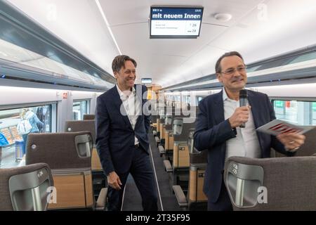 23. Oktober 2023, Hessen, Frankfurt/Main: Michael Peter (l), Vorstandsvorsitzender von Siemens Mobility, und Michael Peterson, Vorstandsmitglied der Deutschen Bahn (DB), präsentieren den ersten ICE 3 Neo mit neuem Innenraum am Hauptbahnhof. Mit neu entwickelten Sitzen und einem „modernen Material- und Farbkonzept“ werden die Passagiere ab sofort in den Zügen mit einer Geschwindigkeit von 300 ein „Wohnzimmer-Feeling“ haben. Foto: Helmut Fricke/dpa Stockfoto