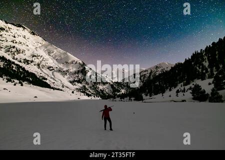 Wanderer genießen Sternenbeobachtung in einer schneebedeckten Berglandschaft in den Pyrenäen Stockfoto