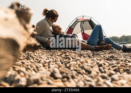 Glückliches junges paar Entspannung in einem Zelt am Flußufer Stockfoto