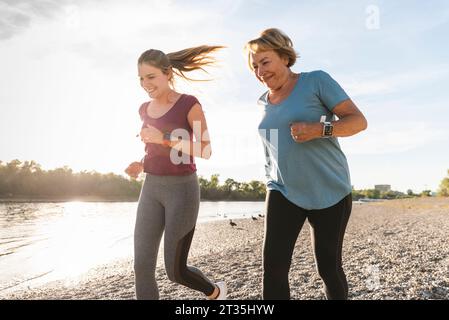 Enkelin und Oma Spaß, Joggen am Fluss Stockfoto
