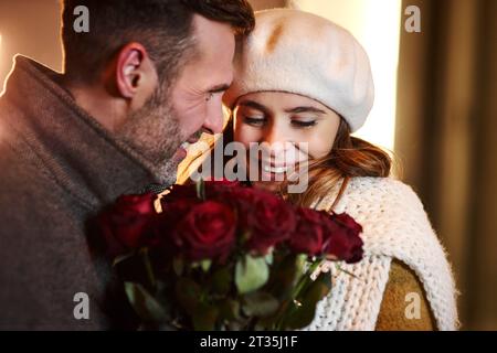 Ein Paar, das im Winter in rote Rosen verliebt ist Stockfoto