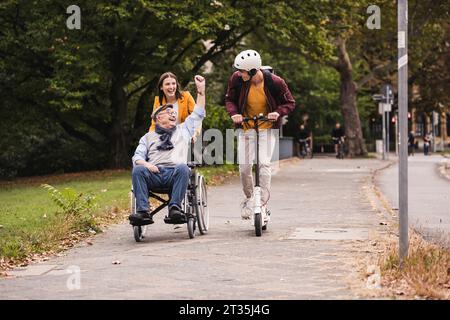 Älterer Mann im Rollstuhl Spaß mit seinem Enkel im Freien für Erwachsene Stockfoto