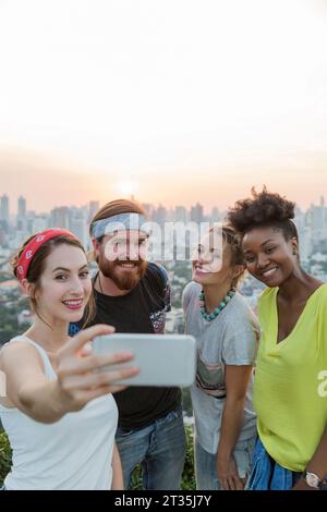 Frau, die Selfie mit Freunden vor dem Sonnenuntergang macht Stockfoto