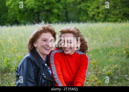 Glückliche Mutter und Tochter lachen im Feld Stockfoto